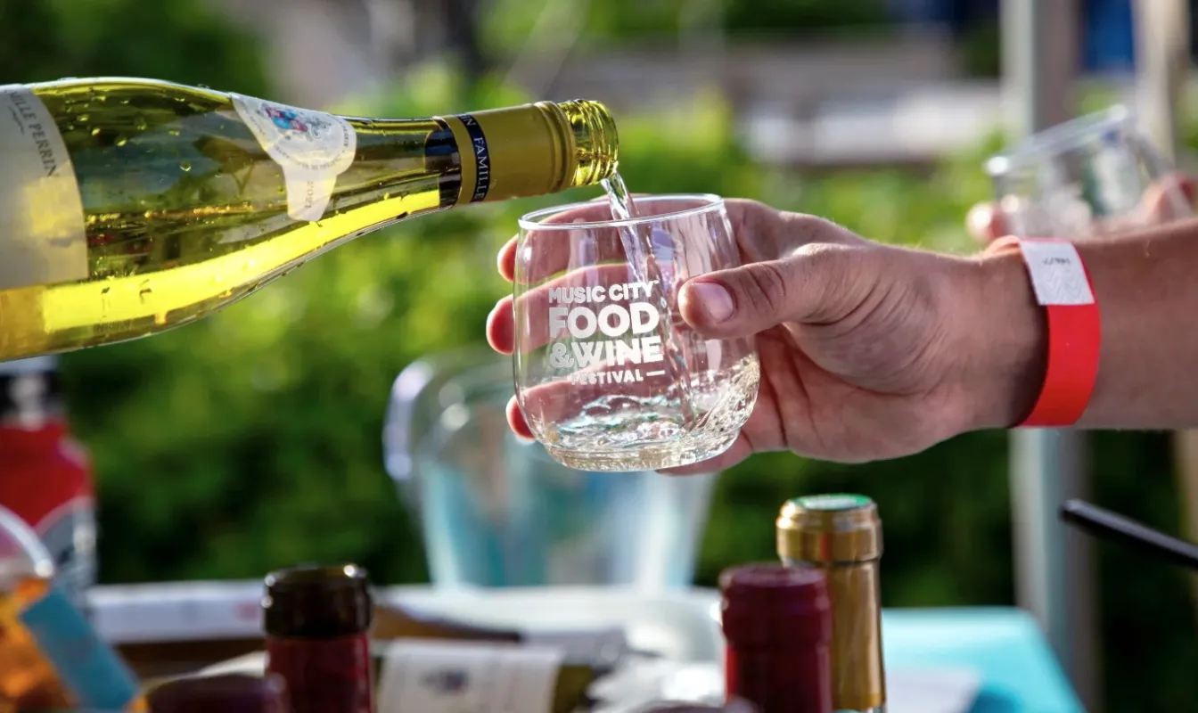 Bottle of wine being poured into a glass at the Music City Food and Wine Festival 