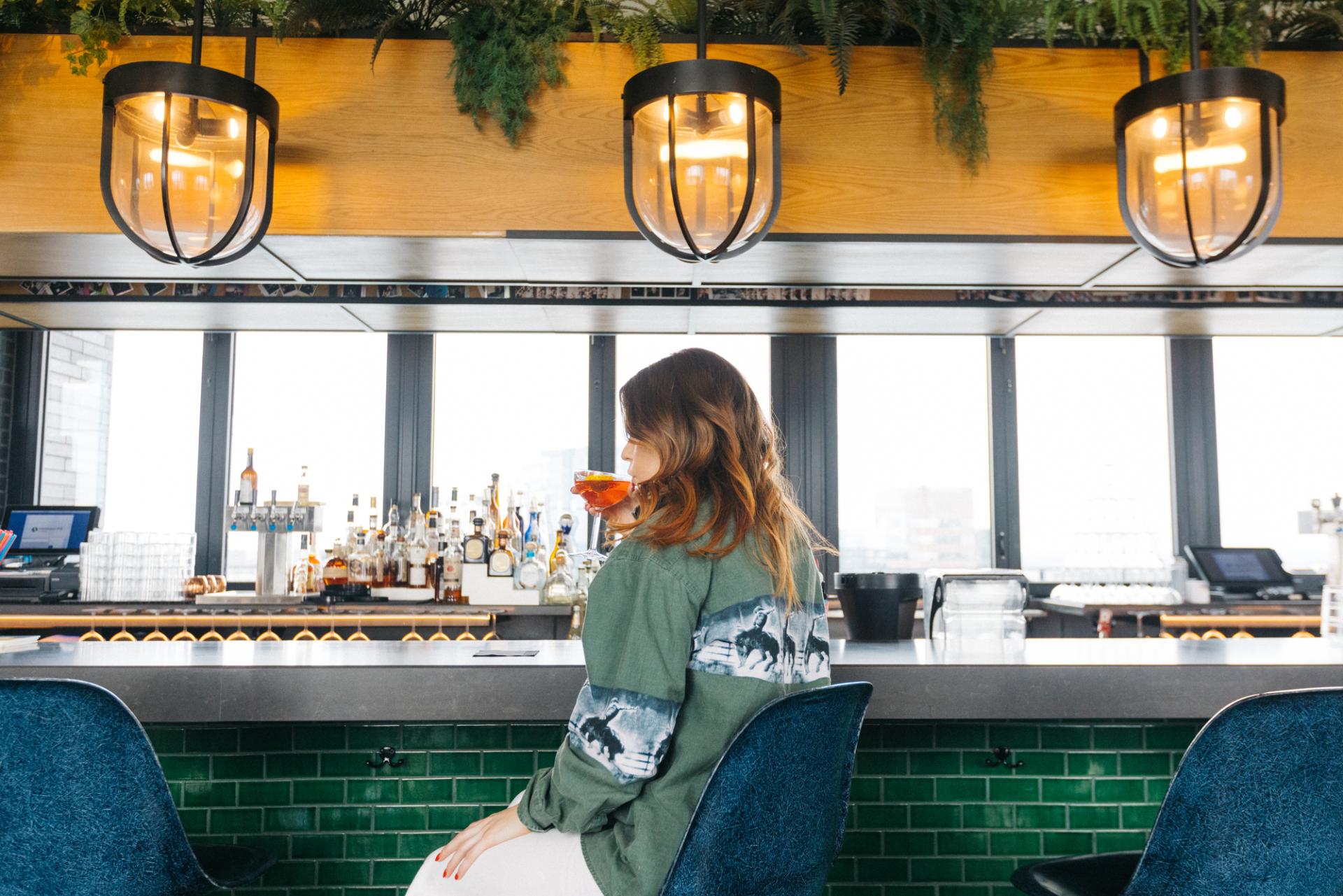Girl sitting at bar at Virgin Hotel