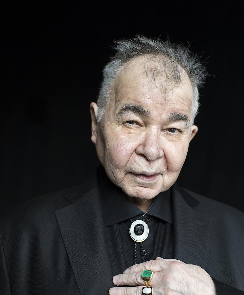 Portrait of John Prine in a black suit