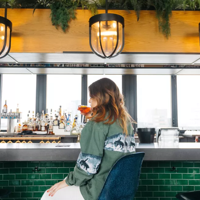 Girl sitting at bar at Virgin Hotel