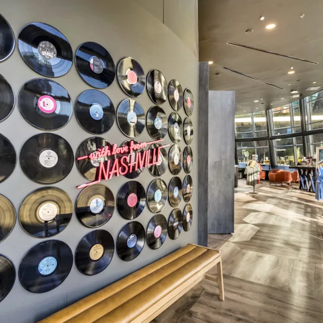 Wall decorated with vinyl records and a neon Nashville sign inside a retail store