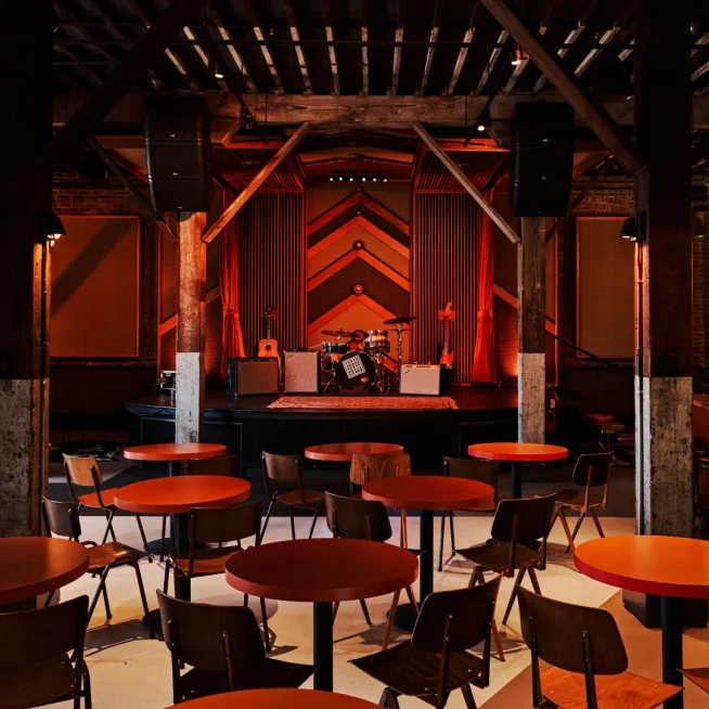 Emulating a live recording studio with quality sound and stage, our Mid Century inspired honky tonk with neon laminate tables, studio-inspired decor and quilted vinyl booths, allow for an enjoyable space.