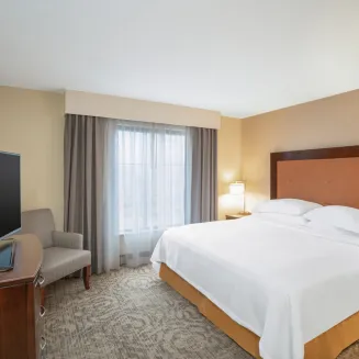 Spacious King Bedroom area, separate from the living room area in each suite.  Features plush bed and bedding package.
