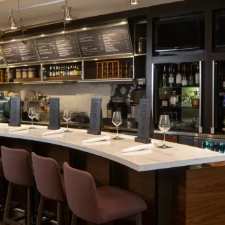 Hotel bar and bistro area with counter seating and drink displays.