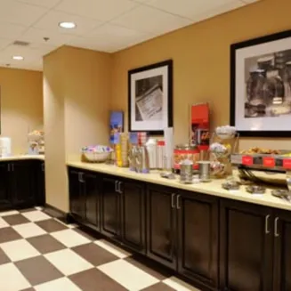Hotel breakfast area with self-serve food and beverage stations.