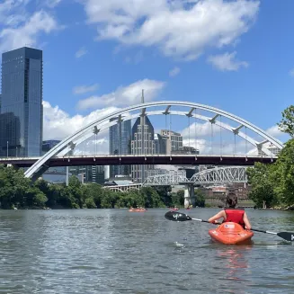 A kayaker on the Cumberland River approaches downtown Nashville, TN.