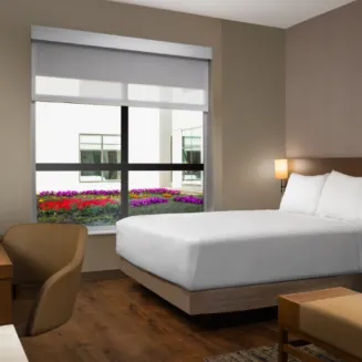 Look out onto the rooftop garden from this 264–275-square-foot room featuring one king bed, a Cozy Corner with a sleeper sofa and a work desk.