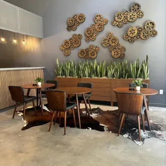 Table seating in the lobby on level 1. This is accompanied by a reception area, coffee and water machine, and additional couch seating.