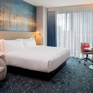 Relax and recharge in a guest room that's been re-imagined around you, complete with a Get Ready Zone that's perfect for whatever you're up for: getting ready for the day or a night out, finishing some work, or eating a quick bite. This stylish 330 sq. ft. room with a king bed features a 65-inch TV, complimentary Wi-Fi, mini-refrigerator, Apotheke bath amenities, Bluetooth speaker in the bathroom mirror, and elevated salon quality hair dryer. Rest easy on the Sealy Accelerate mattress, exclusive to Tempo. T