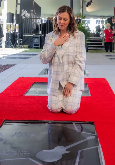 Fiona Prine kneels over her late husband's star