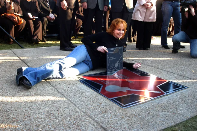 Reba poses with her star on the Music City Walk of Fame.