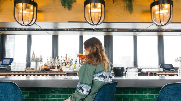 Girl sitting at bar at Virgin Hotel