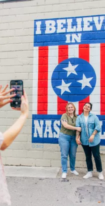 Girls taking photo with mural in 12South